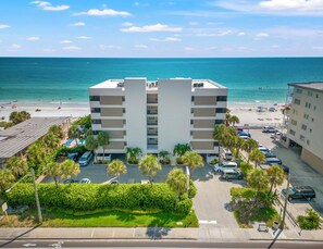 A multi-story hotel with a pool area and beach view.