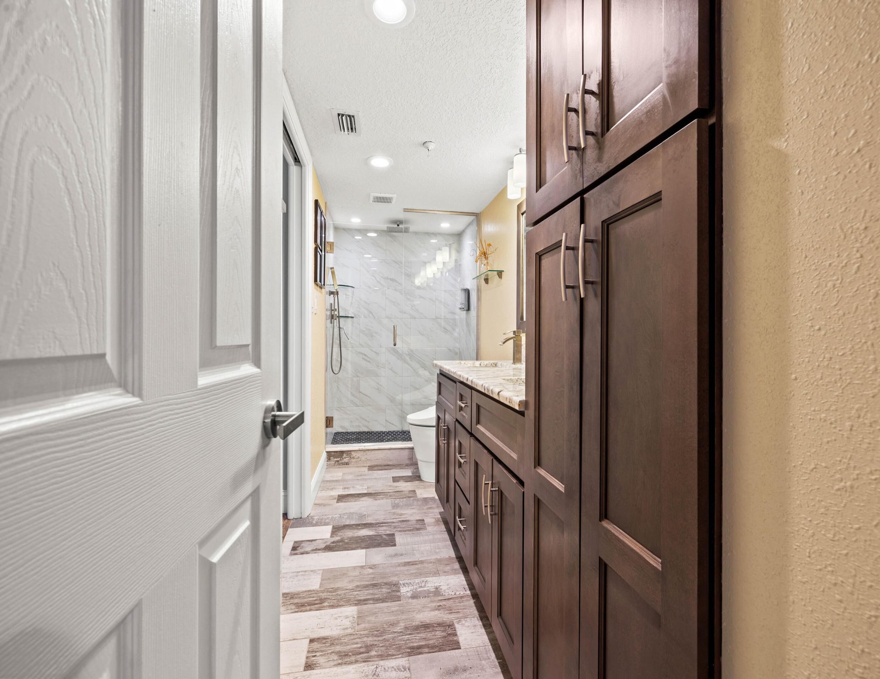 A narrow hallway with a wooden cabinet and a marble-tiled floor.