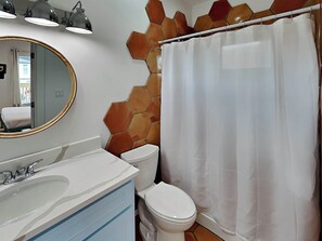 A bathroom with a white sink, a toilet, and a shower curtain.