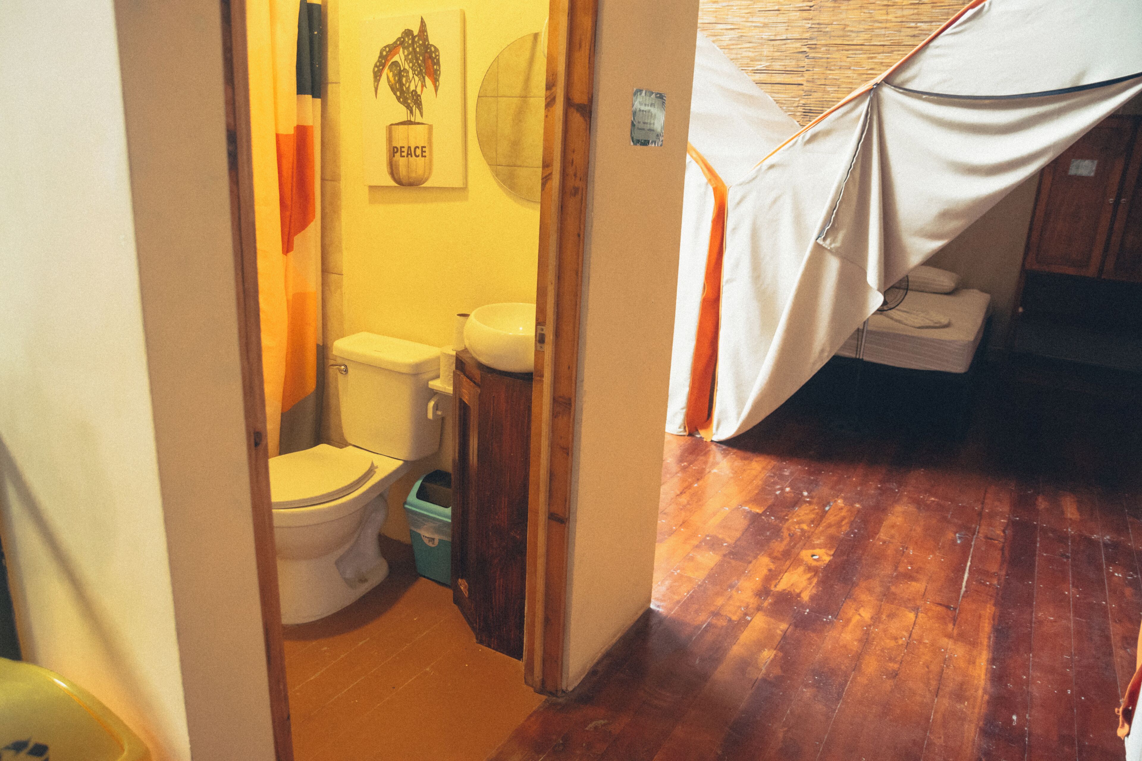 A small bathroom with a toilet, sink, and a wooden floor.