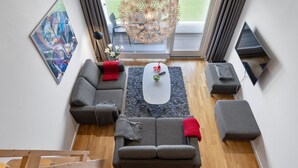 Een moderne woonkamer met een hoekbank, een salontafel en een televisie.