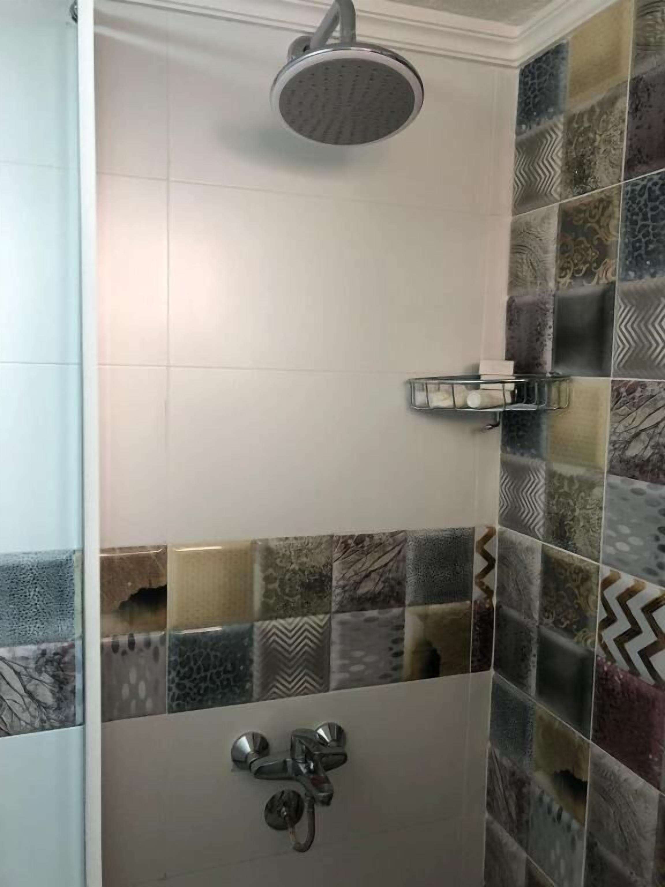 Un área de ducha con cabezal de ducha de lluvia y cabezal de ducha manual.