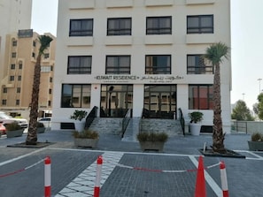 A multi-story building with a sign reading 'KUWAIT RESIDENCE'.