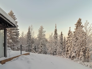 Schneebedeckte Landschaft mit einem Gebäude und Bäumen.