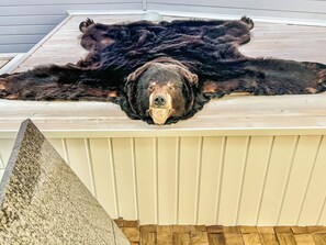 Un oso descansando sobre una cubierta de madera.
