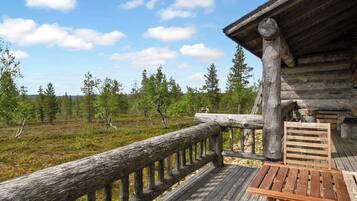 A wooden deck with a railing, a bench, and a table.
