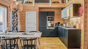 A modern kitchen with a central island, a dining area with a table and chairs, and a loft space with a unique animal-themed decor.