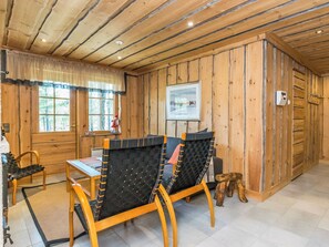 A wooden interior with a dining table, chairs, and a window with curtains. - Kiela 1 by Interhome (Inari)