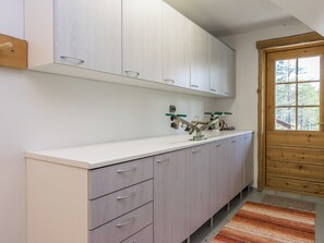 Une cuisine avec des armoires blanches, un plan de travail et une porte en bois.