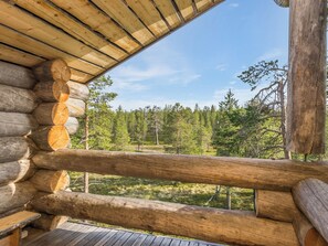 A log cabin with a wooden deck and a view of a forest. - Kiela 1 by Interhome (Inari)