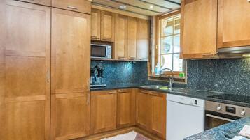 A kitchen with wooden cabinets, a microwave, a sink, and a dishwasher.