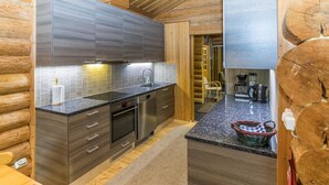 A modern kitchen with dark wood cabinets, stainless steel appliances, and a granite countertop.
