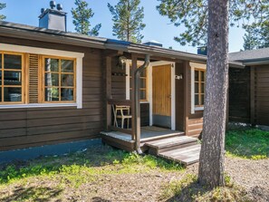 A wooden cabin with a porch, a door marked with the number 4, and a window with shutters.