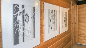 Un couloir aux murs recouverts de lambris en bois et ornés d’œuvres d’art en noir et blanc, encadrées.