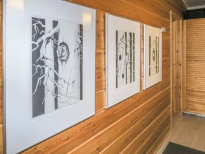 A hallway with wooden paneling and framed artwork on the wall.