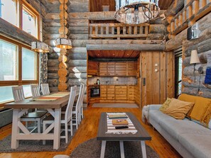 L’intérieur d’une cabane en rondins comprend un coin repas, une cuisine et un espace de vie.