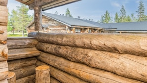Une cabane en rondins avec une façade en bois et une véranda couverte.