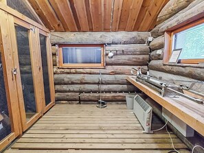 Ein Holzhaus-Innenraum mit Holzboden, einem Fenster, einem Spülbecken und einer Heizung.