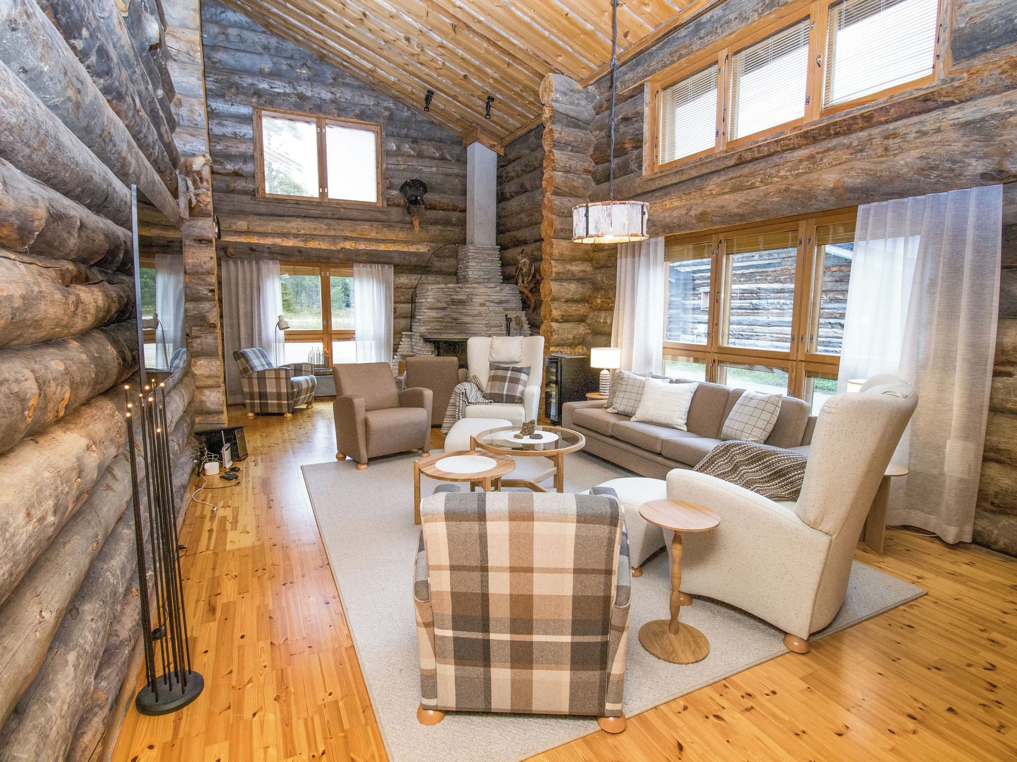 A log cabin interior with a fireplace, wooden floors, and a cozy seating area.