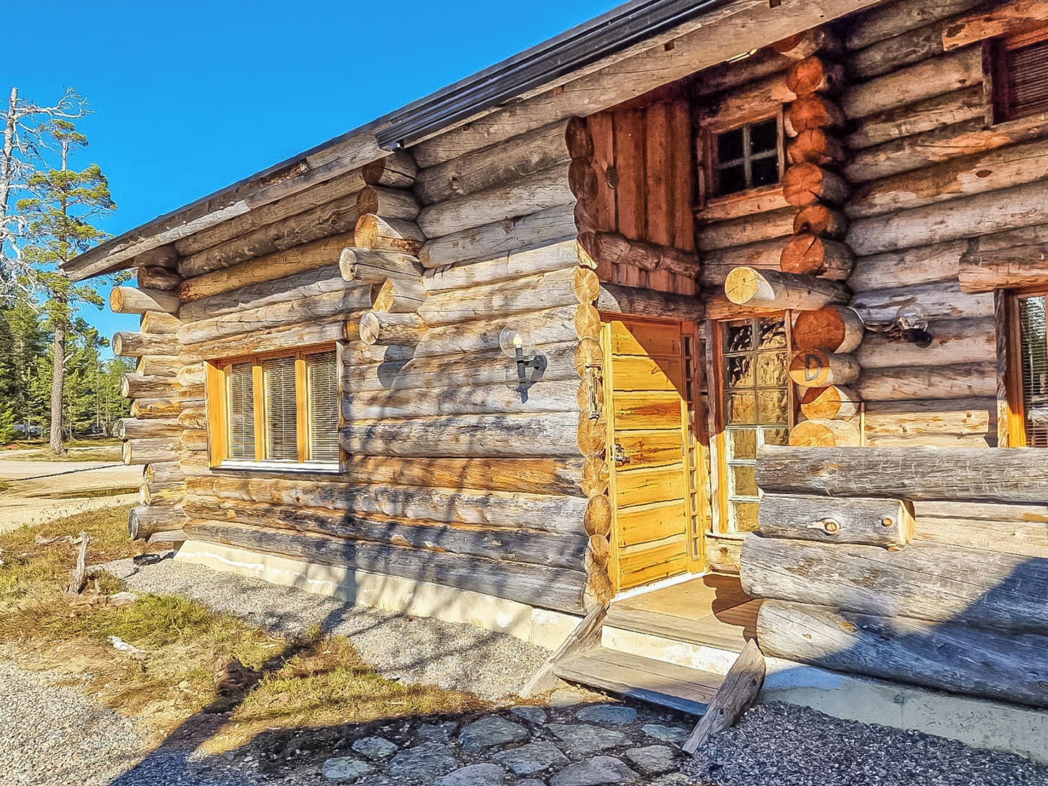 A log cabin with a wooden door, windows, and a porch.