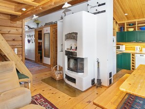 A wooden interior with a fireplace, a dining area, and a kitchen.