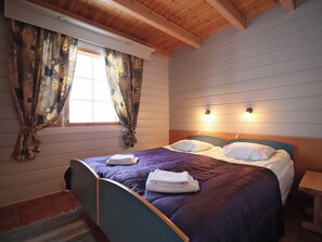 Ein Schlafzimmer mit einem Bett, Vorhängen und einem Fenster.