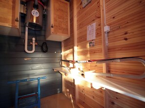 Una cocina con paredes de madera, un lavamanos y una ventana.