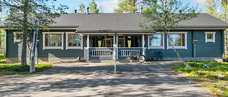 A two-story house with a porch, a bicycle, and a mailbox.