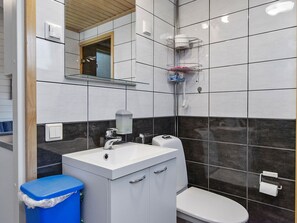 Une salle de bain moderne avec un lavabo blanc, des toilettes et un espace douche.