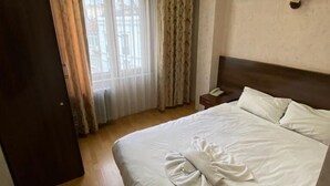 Camera d'albergo con un letto grande, un comodino, una lampada e un condizionatore d'aria a parete.