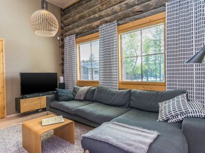 A modern living room with a sectional sofa, a flat-screen TV, and a wooden coffee table.
