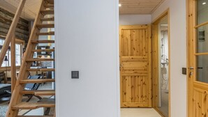 Una escalera de madera conduce a un entrepiso con cocina y comedor.