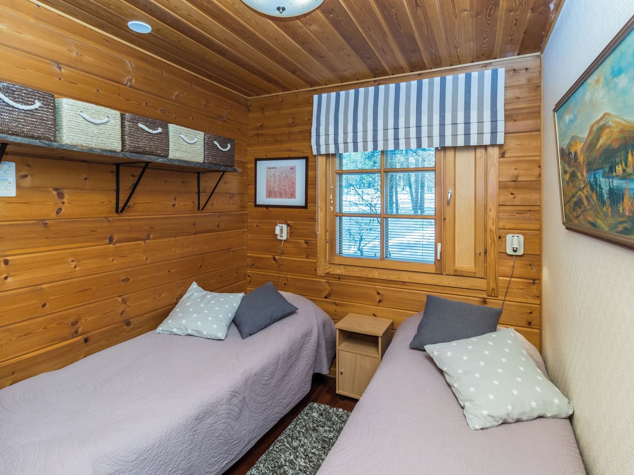 Een chalet met twee eenpersoonsbedden, een raam met uitzicht op bomen en een houten wand met een kaart.