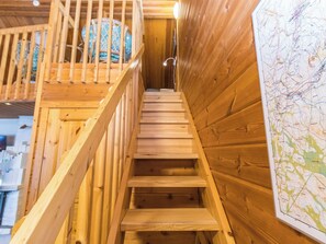 A wooden staircase with a handrail and a view of a map on the wall.