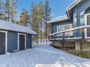 Un sentier enneigé mène à un chalet doté d’une terrasse et d’un garage.