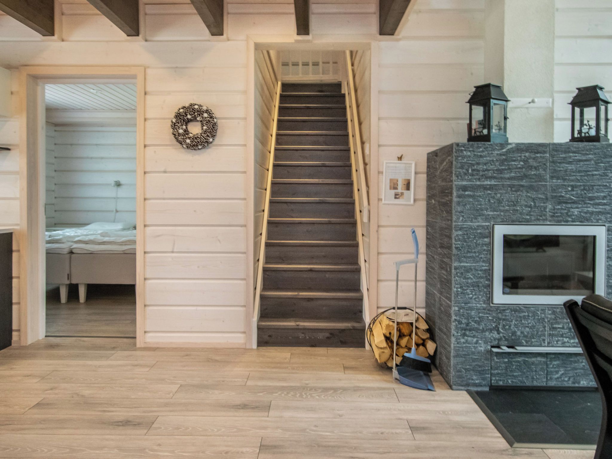 A staircase leading to a bedroom, a fireplace with a stone surround, and a wall-mounted lantern.