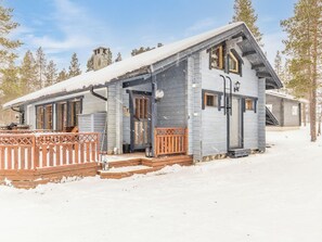 A cabin with a wooden deck, a covered porch, and a chimney. - Aihki 1 by Interhome (Inari)