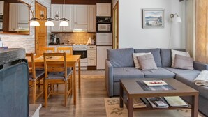 Ein modernes Wohnzimmer mit grauem Sofa, einem Holzesstisch und einem Couchtisch.
