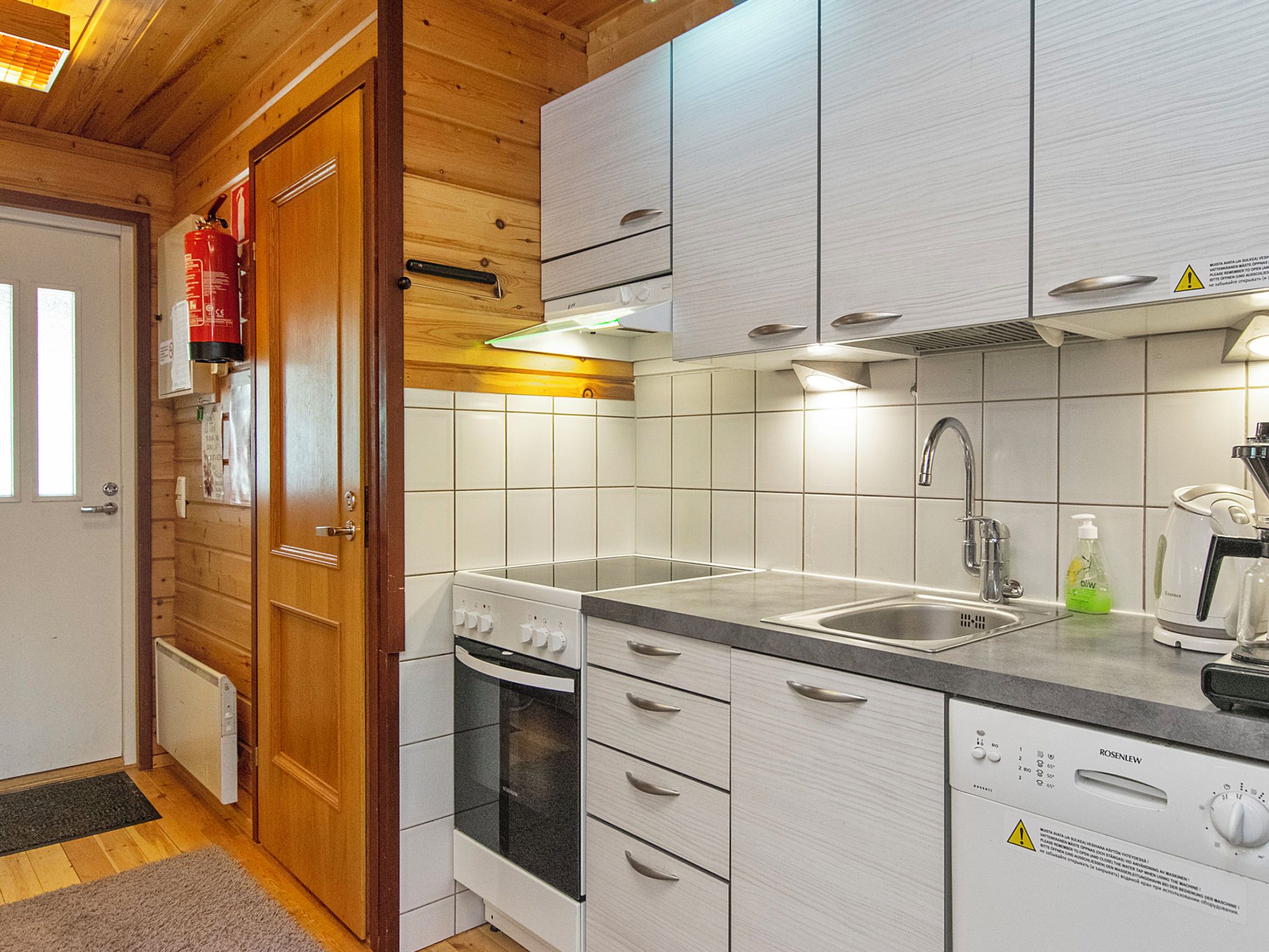 Een moderne keuken met witte kasten, een ingebouwde oven, een roestvrijstalen spoelbak en een vaatwasser.