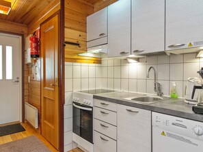 A modern kitchen with white cabinetry, a built-in oven, a stainless steel sink, and a dishwasher.
