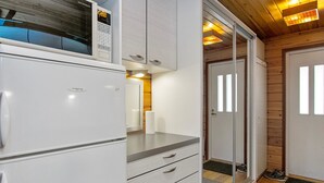 Cocina compacta con microondas, refrigerador y una pequeña encimera.