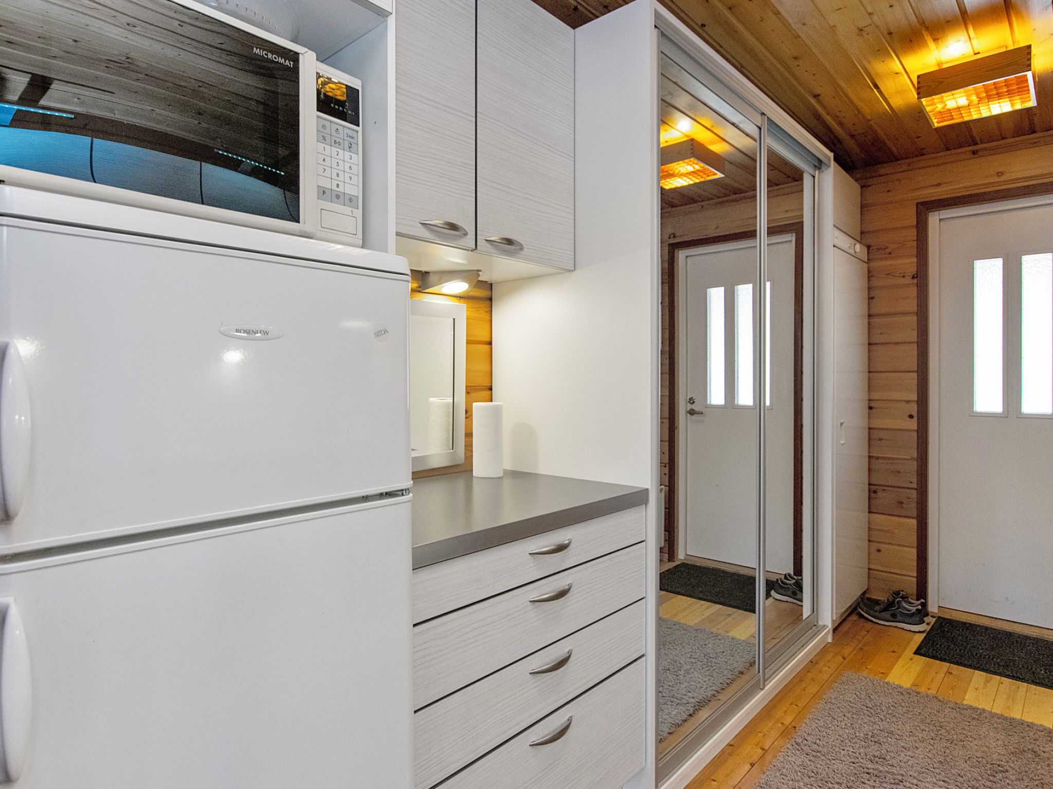 A compact kitchen with a refrigerator, microwave, and a small countertop.