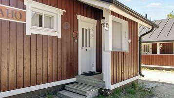 A wooden building with a white door, a small porch, and a mailbox.