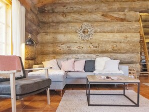 A cozy log cabin interior with a sofa, armchair, and a coffee table. - Kauniskelo a by Interhome (Inari)