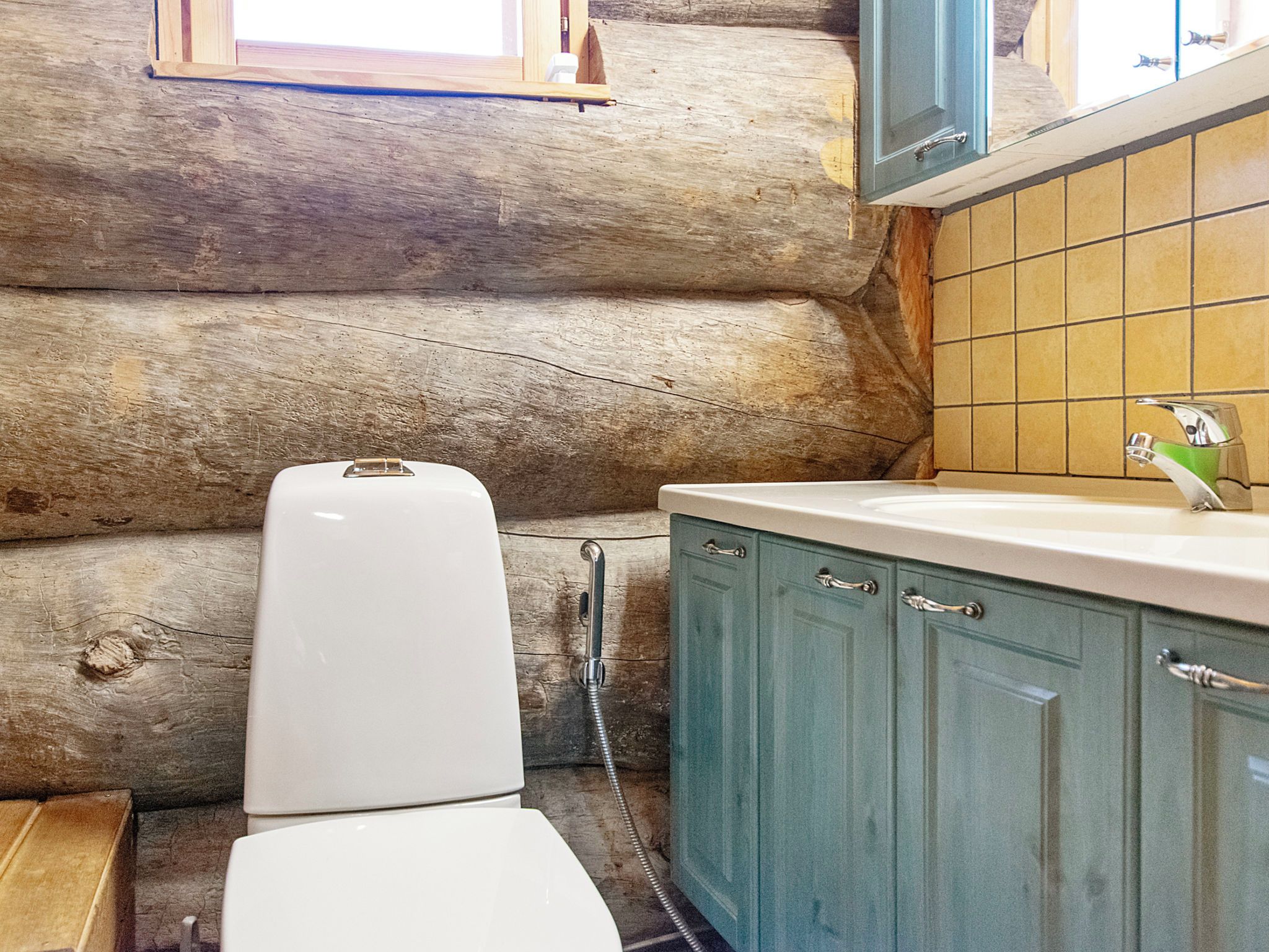Une petite salle de bain comprenant des toilettes, une douche et un lavabo avec des placards.