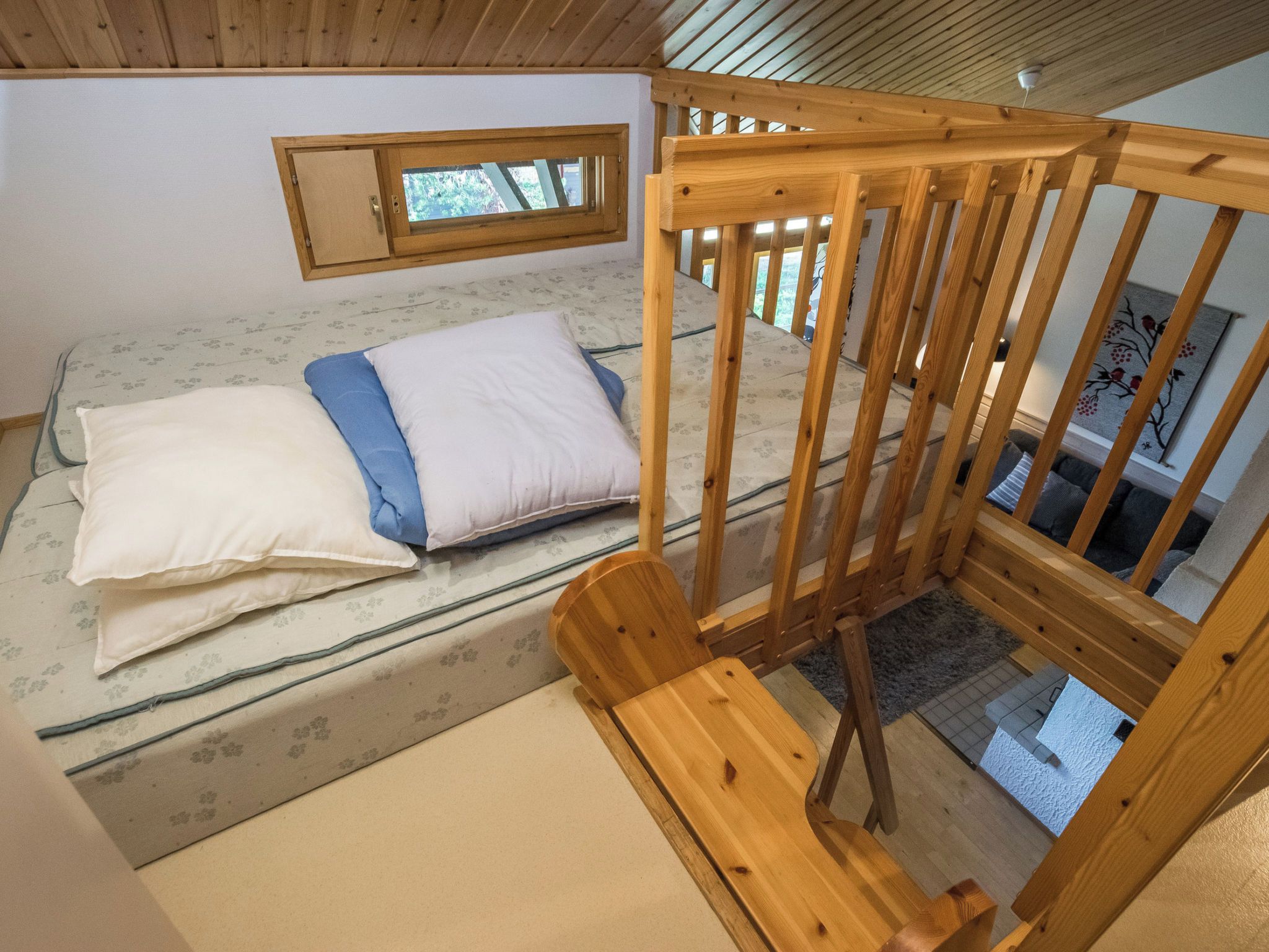 A room with a bed, a wooden chair, and a window.