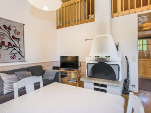 Un salon chaleureux avec une cheminée, un téléviseur et un tableau accroché au mur.