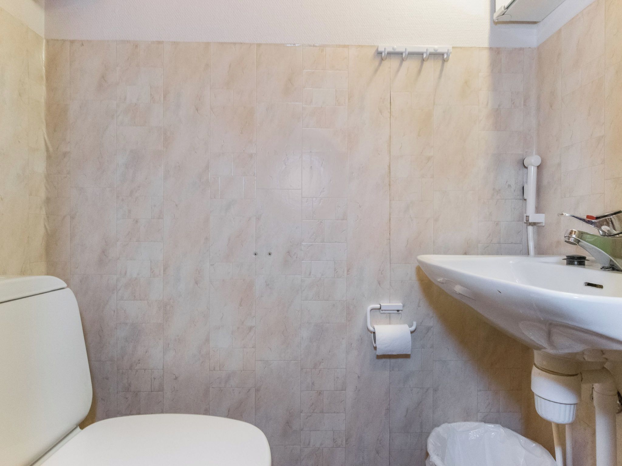 Ein Badezimmer mit Toilette, Waschbecken und Duschbereich.