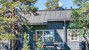 A two-story house with a dark gray exterior, a chimney, and a front porch.