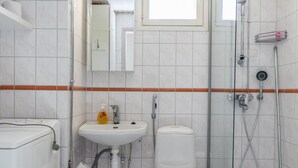 Un baño con inodoro, lavabo y ducha.